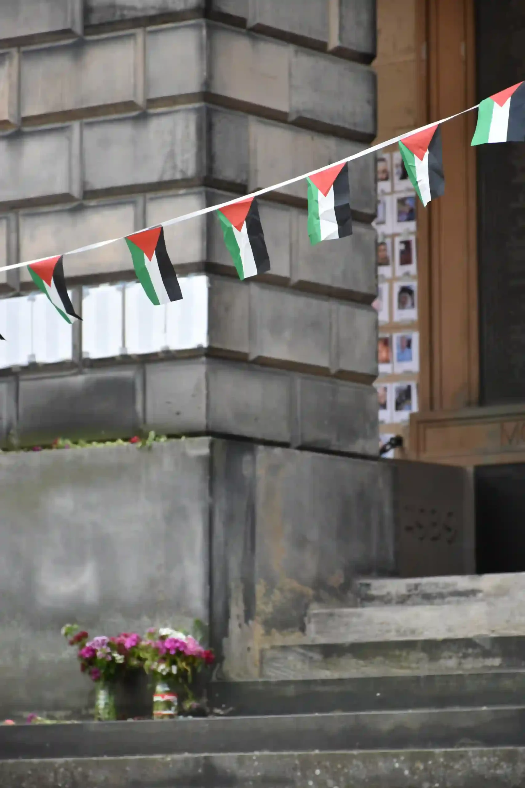 Palestinian flags in front of lists of names of people killed in Gaza at the memorial in the University of Edinburgh old quad