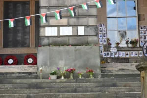 Photograph of a pillar and flowers laid at the memorial to civilian lives lost in Gaza at the University of Edinburgh